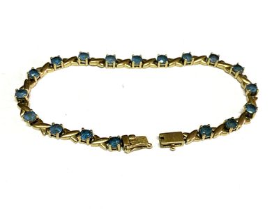 un gros plan d'un bracelet orné de pierres bleues sur fond blanc