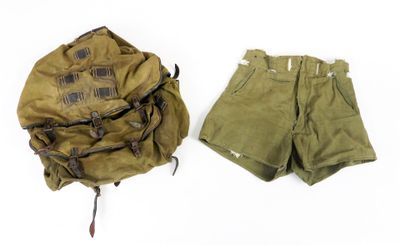 un short militaire et un sac à dos posés sur une surface blanche