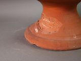 a red vase sitting on top of a gray table