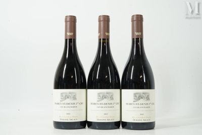 trois bouteilles de vin rouge sont posées sur une surface blanche