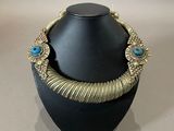 a close up of a necklace on a mannequin on a table