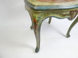 une petite chaise en bois dont l'assise est ornée d'un motif floral