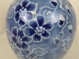 a blue and white vase sitting on a white surface