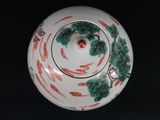a white bowl with red and green designs on it