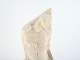 a white sculpture of a man standing on a rock