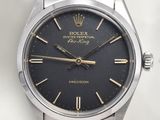 une image d'une montre Rolex avec un cadran noir et des aiguilles dorées