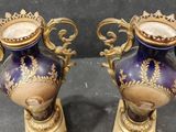 pair of purple and gold vases sitting on top of a black table