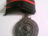 une médaille d'argent ornée d'un ruban rouge et noir