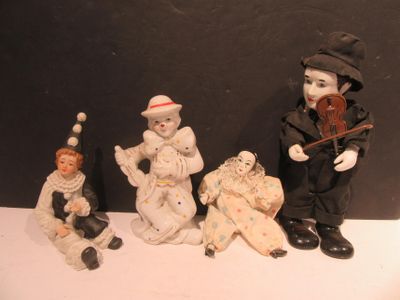 five figurines of clowns sitting on a table