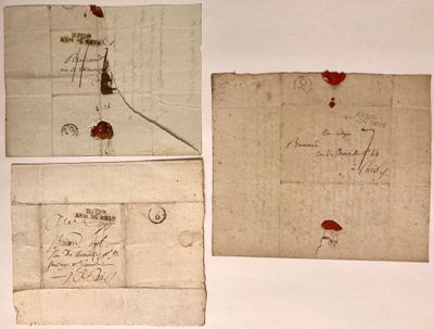 trois vieux morceaux de papier sur lesquels sont inscrits des mots, posés sur une table