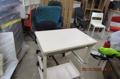 une table blanche avec une chaise bleue au milieu d'une pièce