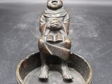une image représentant une statue d'une femme assise sur un bol