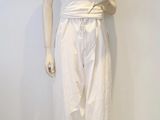 un mannequin vêtu d'un haut et d'un pantalon blancs, posé sur un socle