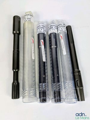 quatre stylos et un pot à stylos posés sur une table