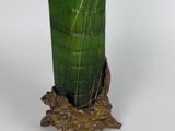 a green vase that is sitting on top of a tree stump