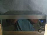 Quelqu'un prend une photo d'un micro-ondes posé sur une table en bois.