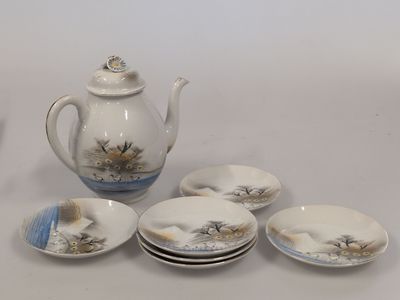 une théière et quatre assiettes sur lesquelles est représentée une théière