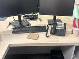 un bureau sur lequel se trouvent deux écrans d'ordinateur et un téléphone