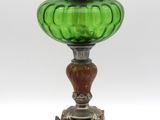 une lampe ancienne en verre vert avec un pied en métal, sur fond blanc
