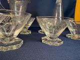 four glasses and a pitcher sitting on a table