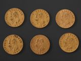 six gold sovereigns, one of which has a head of a man and four of which are of different