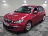 la voiture rouge est garée sur un sol en damier dans le garage