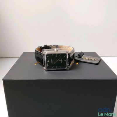 une photo d'une montre posée sur une boîte, elle-même posée sur une table