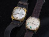 deux montres assises l'une à côté de l'autre sur une surface noire