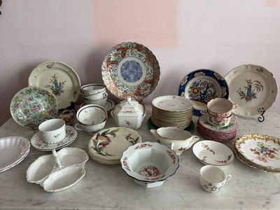 de nombreuses assiettes et bols posés sur une table, avec un mur rose en arrière-plan