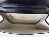 the inside of a black and white purse with a gold chain