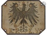 un panneau sur lequel figure un aigle et où l'on peut lire « krp e v »