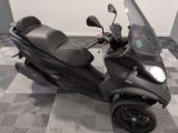 un scooter garé sur un sol à damier