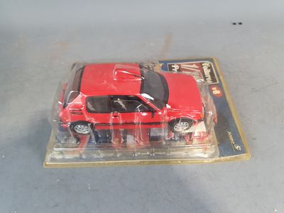 a red toy car in a plastic package on a table