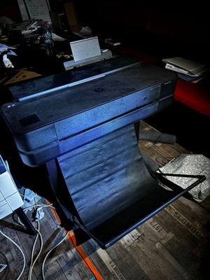 un ordinateur portable posé sur un bureau, à côté d'une imprimante