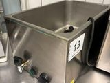 un évier en acier inoxydable posé sur un plan de travail dans une cuisine