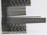 a close up of several pieces of metal wire on a white surface