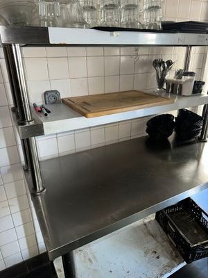 a stainless steel shelf in the middle of a kitchen