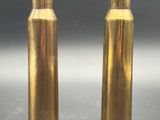deux vases en or posés sur une table, sur fond noir
