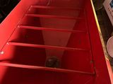 a red machine that is sitting in a garage
