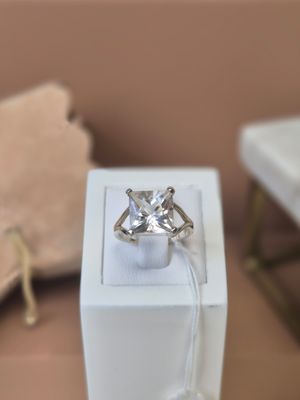une boîte blanche posée sur une table, avec une bague à l'intérieur