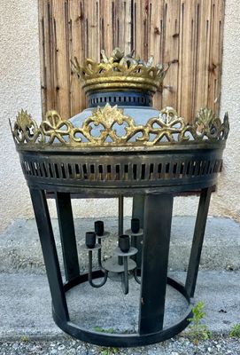 a black and gold fire pit with a crown on top of it
