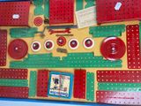 a picture of a red and green crochet board with buttons and pegs