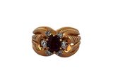 gros plan d'une bague en or avec une pierre rouge