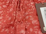 the back of a red dress with a tag on it