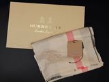 the burbery scarf is next to a gift box on a table
