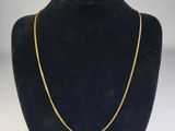 un collier à chaîne en or dans la vitrine d'un mannequin