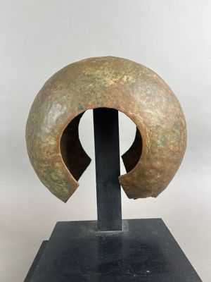 une photo d'une sculpture représentant un casque posé sur un socle noir