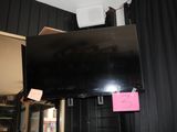 a flat screen tv hanging from the ceiling in a room