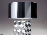 une lampe argentée surmontée d'un abat-jour noir