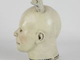 a small statue of a head with a bird on top of it